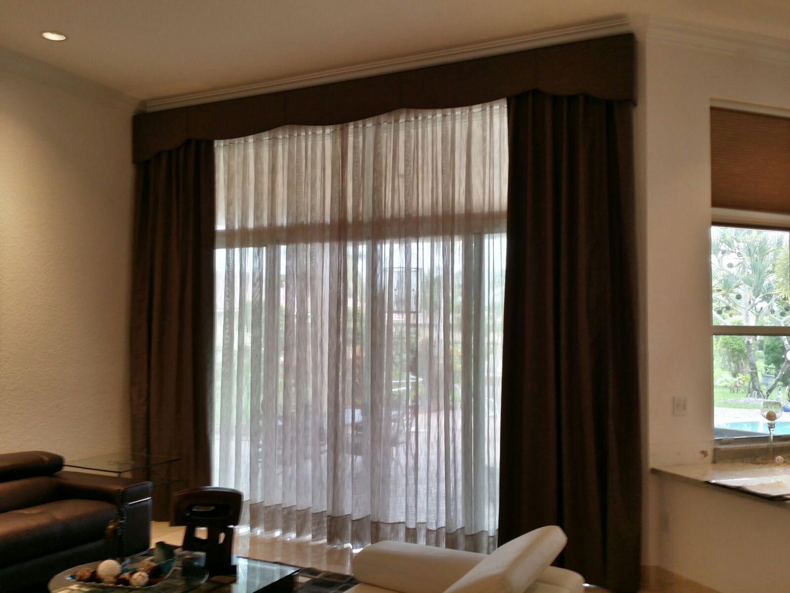 Layered sheer curtains with dark drapery and a shaped valance