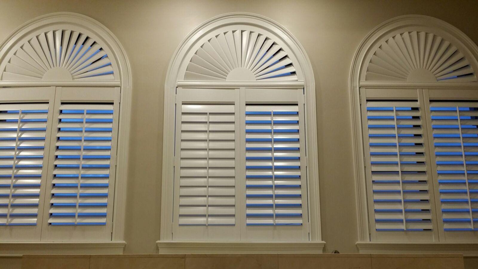 After: three arched windows fitted with white plantation shutters