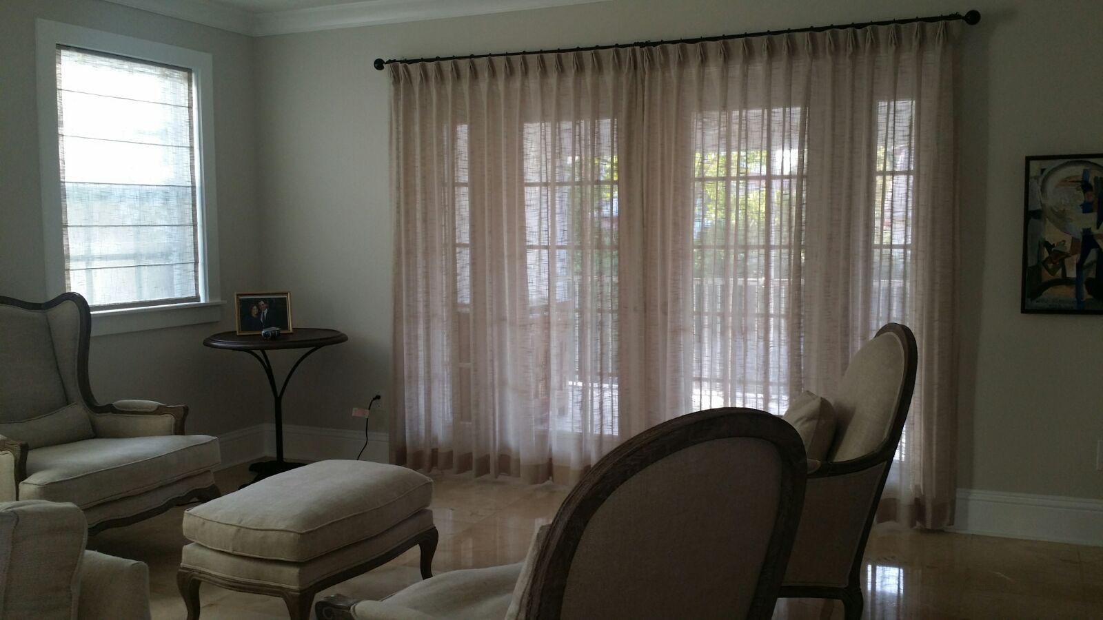 Light sheer curtains framing a sitting room's wide windows